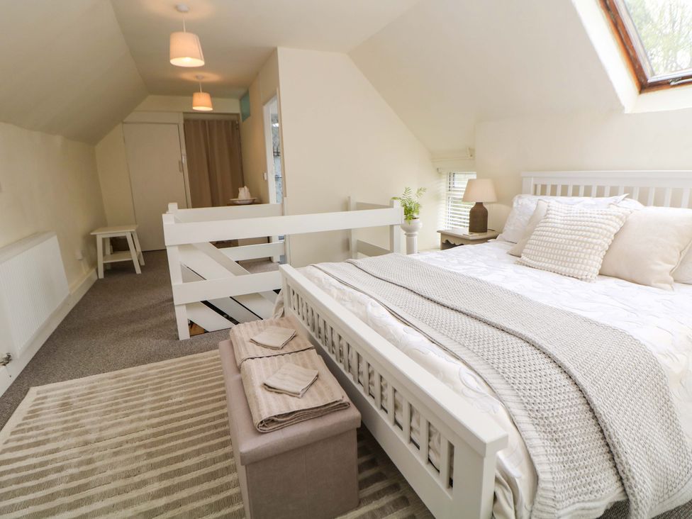 A bedroom with a bed and a bench at Meadow View Cottage Whatstandwell near Crich