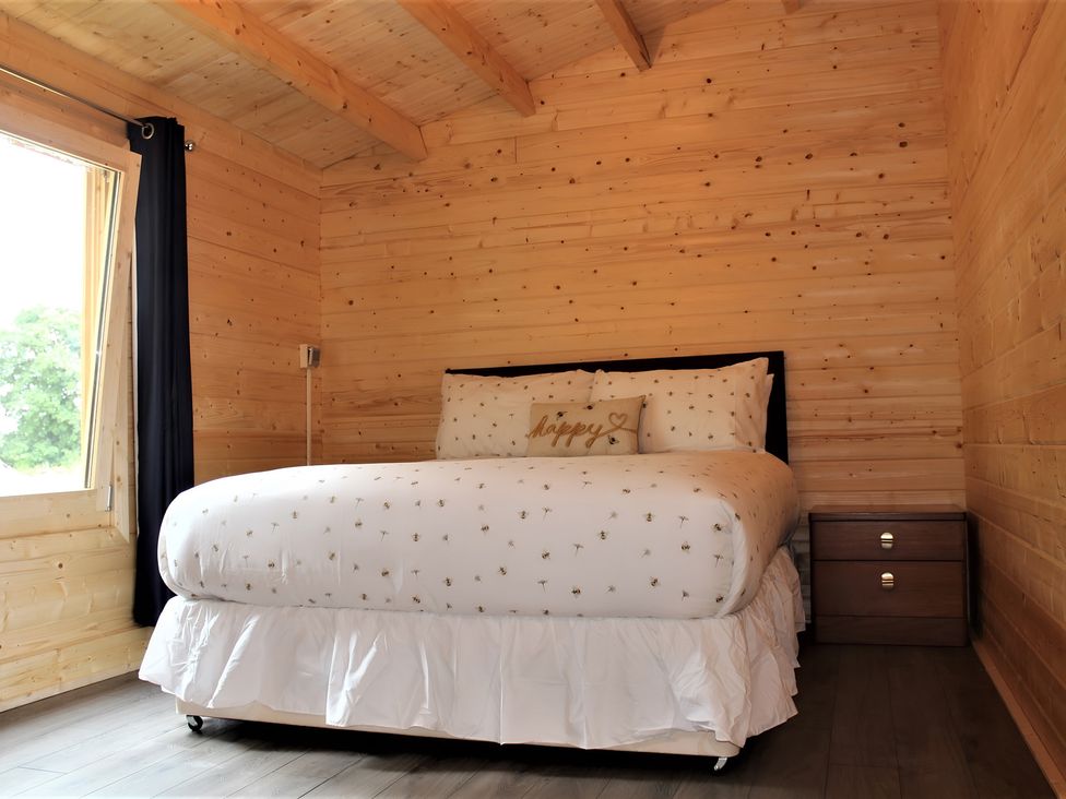 A bedroom with a bed and nightstand at Cotswold Nights Away 1 Evesham