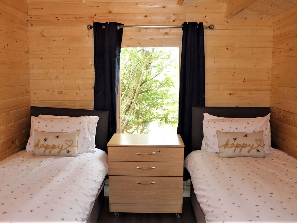 A bedroom with two beds and a nightstand at Cotswold Nights Away 1 in Evesham