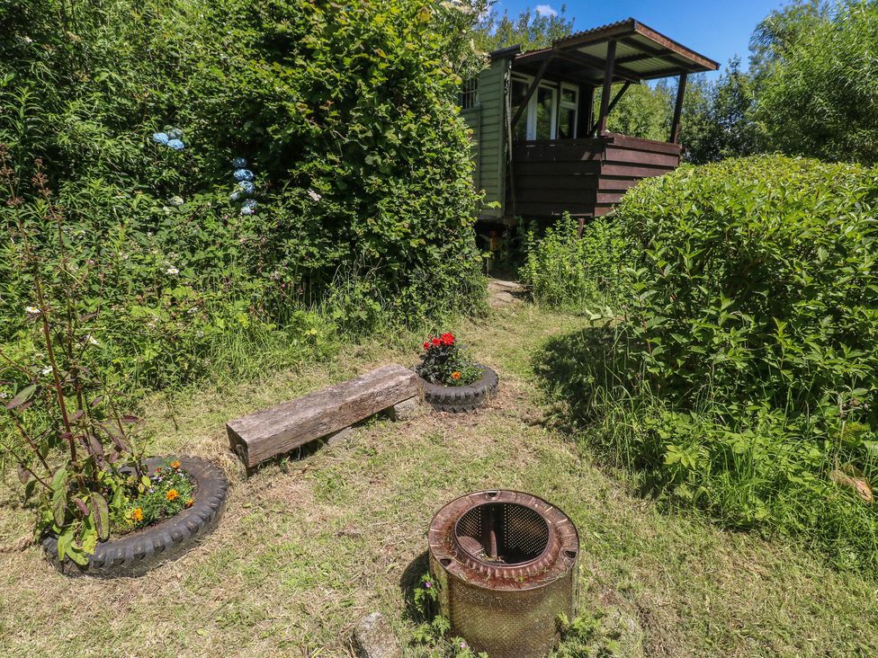 A garden with a wooden bench and tire planters at Rumenco Horse Lorry