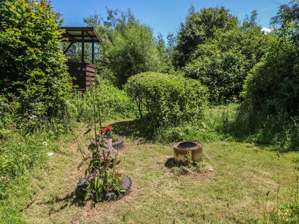 A garden with bushes and a fire pit at Rumenco Horse Lorry