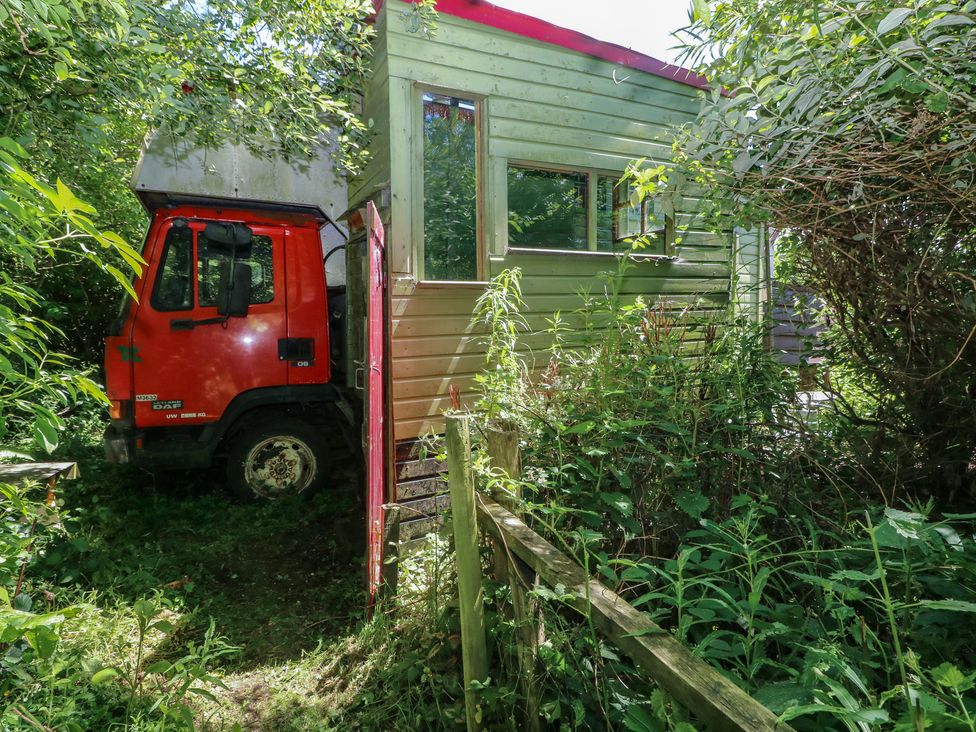 A truck next to a building surrounded by greenery at Rumenco Horse Lorry 