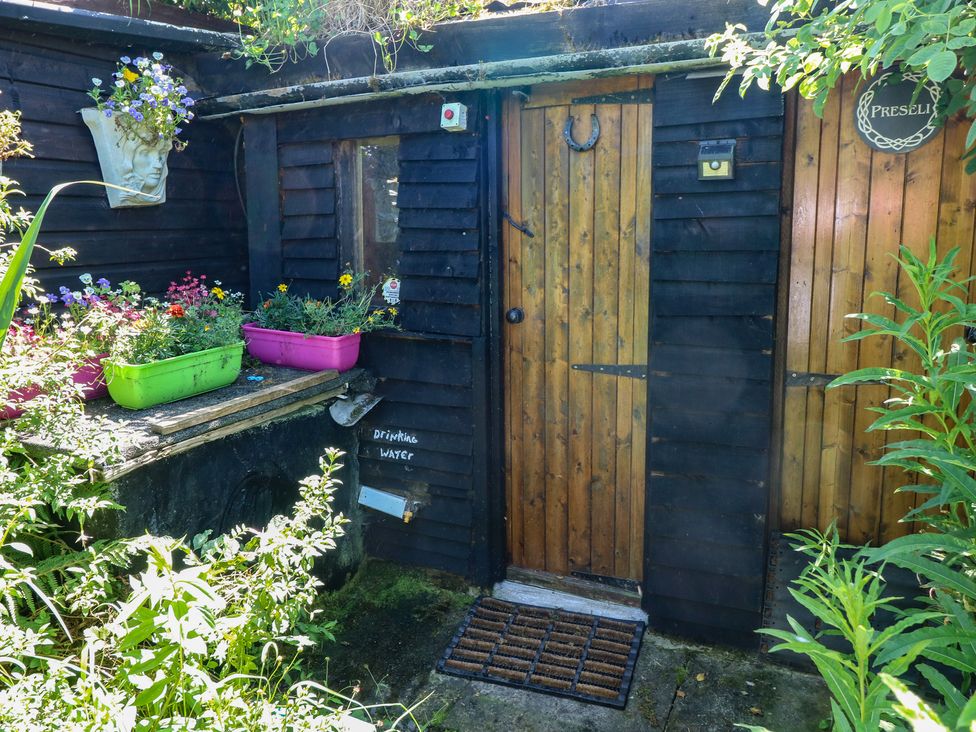 An outdoor area with a wooden door, planters, and flowers at Rumenco Horse Lorry 