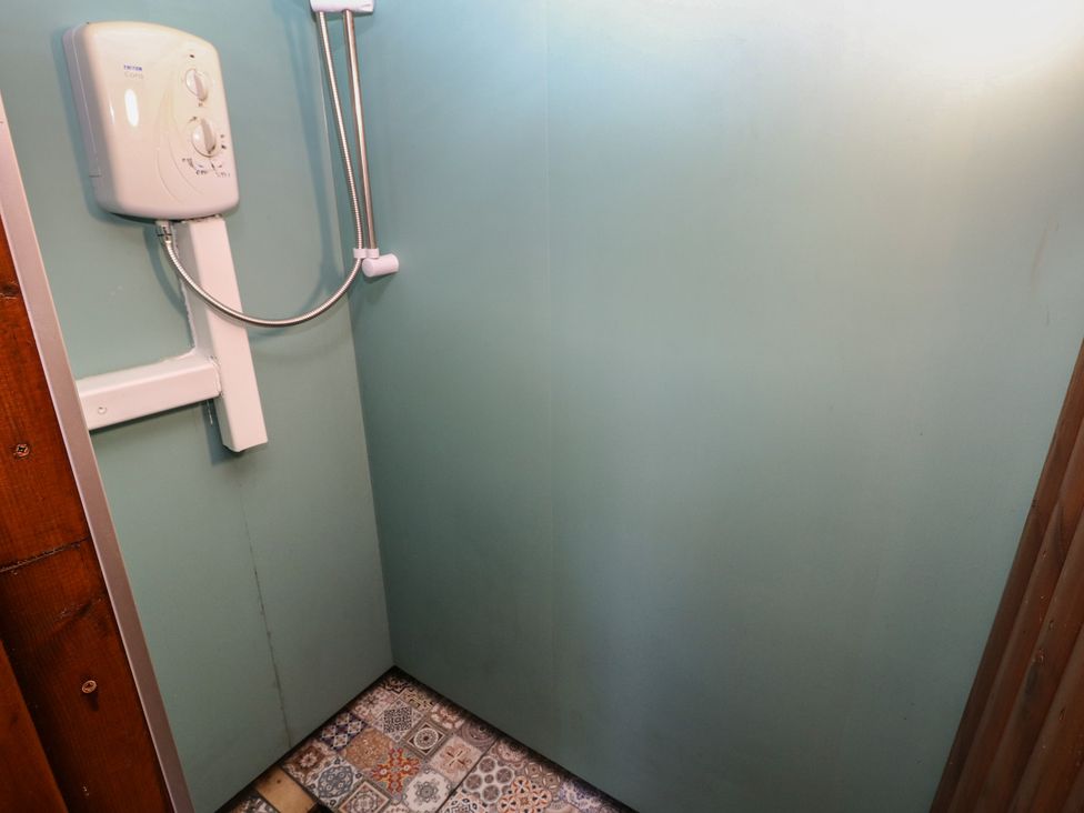 A shower with control unit and patterned floor tiles at Rumenco Horse Lorry 
