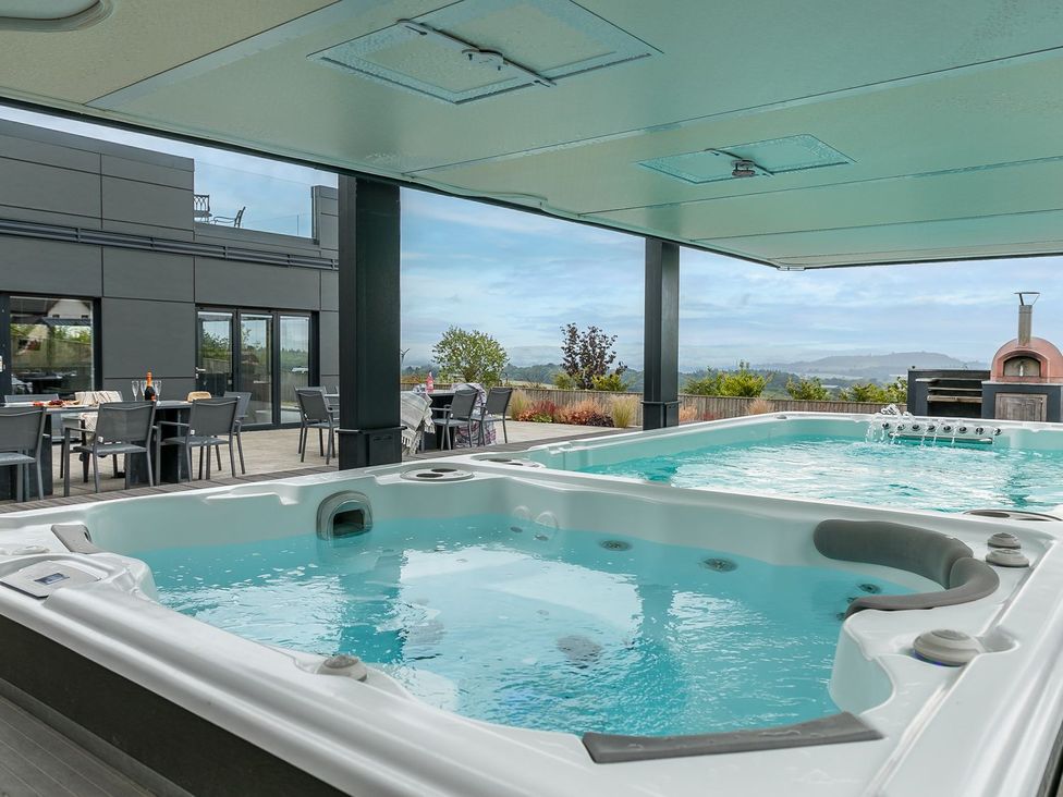 An outdoor area with a spa and seating at Huxham View and Annex Stoke Canon