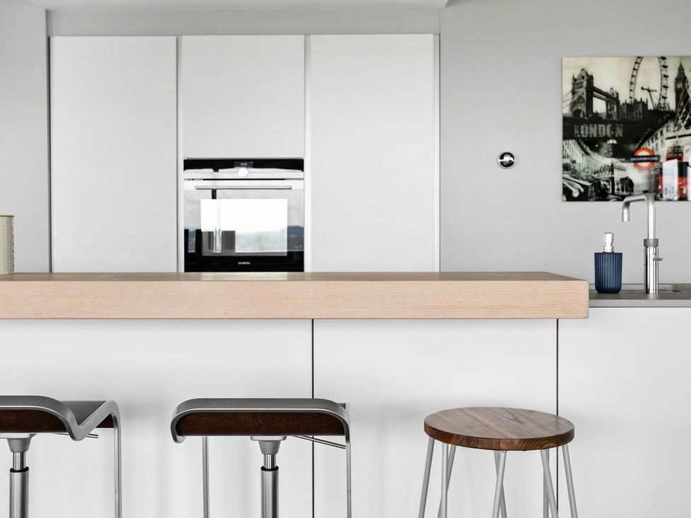 A kitchen with a countertop and bar stools at Huxham View and Annex Stoke Canon