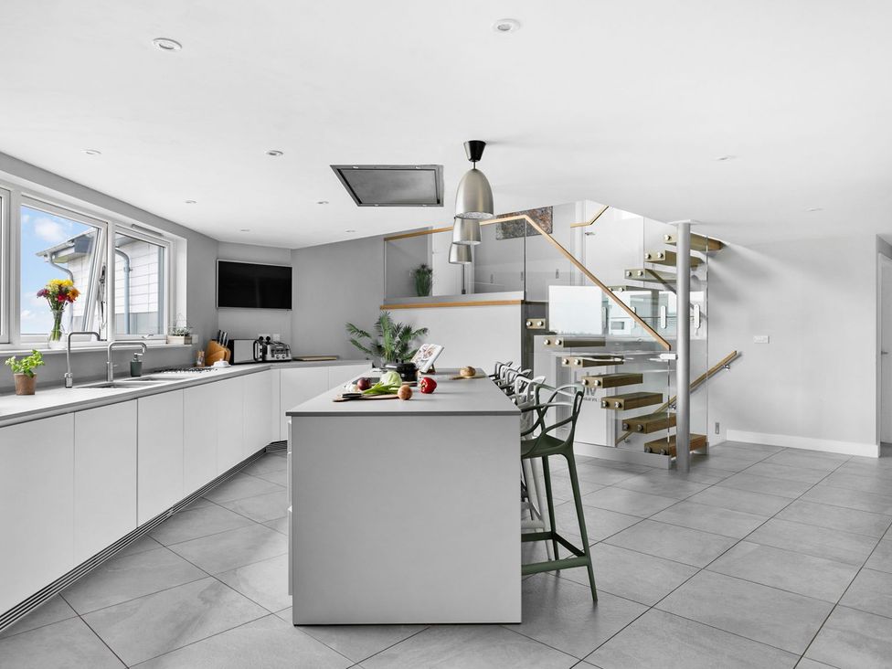 A kitchen with an island and stools at Huxham View and Annex Stoke Canon