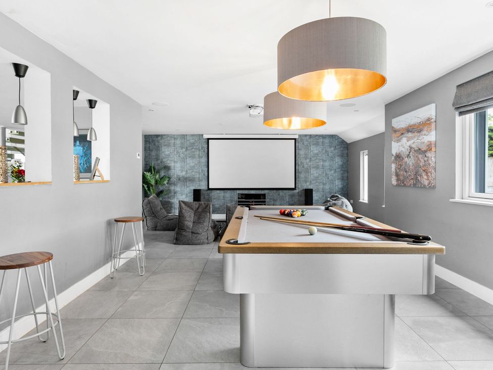 A game room with a pool table and projector screen at Huxham View and Annex Stoke Canon