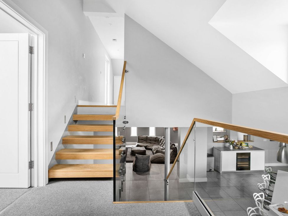 A staircase with a glass railing leading to a living room at Huxham View and Annex Stoke Canon