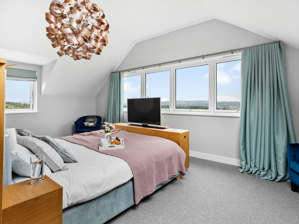 A bedroom with a bed and television at Huxham View and Annex Stoke Canon