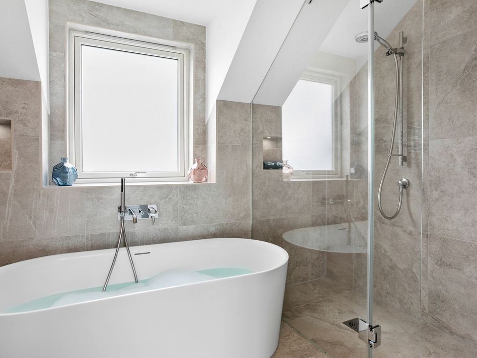 A bathroom with a bathtub and shower at Huxham View and Annex Stoke Canon