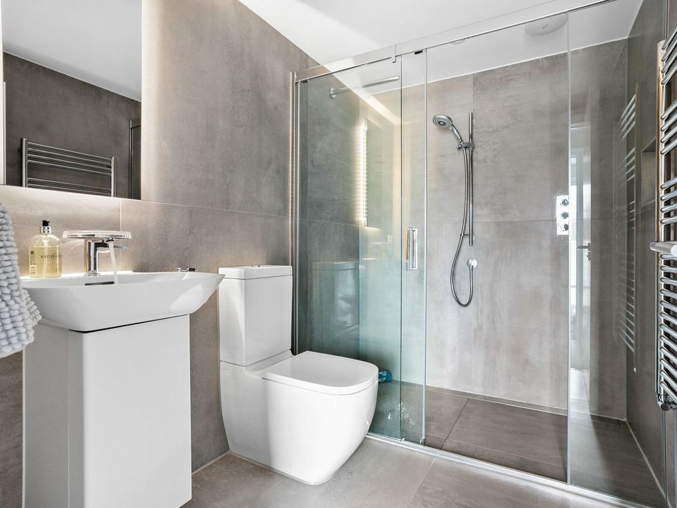 A bathroom with a sink, toilet, and shower at Huxham View and Annex in Stoke Canon