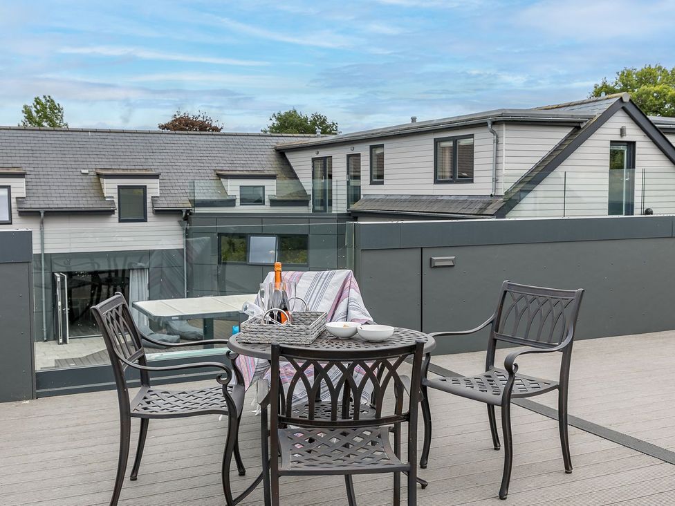 An outdoor seating area with a table and chairs at Huxham View and Annex Stoke Canon