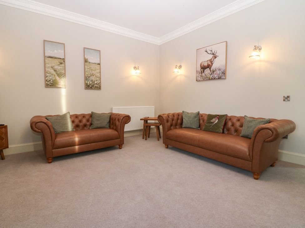 A living room with two sofas and wall art at Balmashanner Farmhouse in Forfar