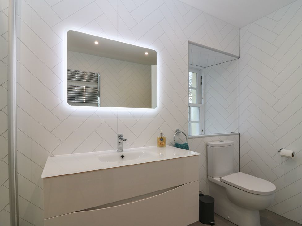 A bathroom with a mirror and sink at Balmashanner Farmhouse in Forfar