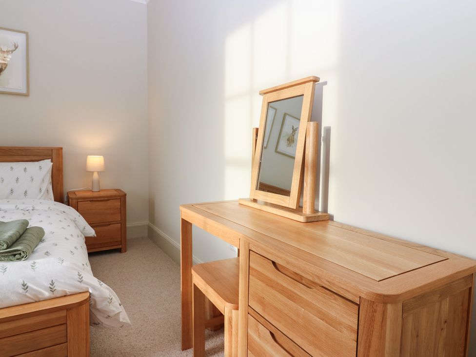 A bedroom with a bed and dresser at Balmashanner Farmhouse Forfar