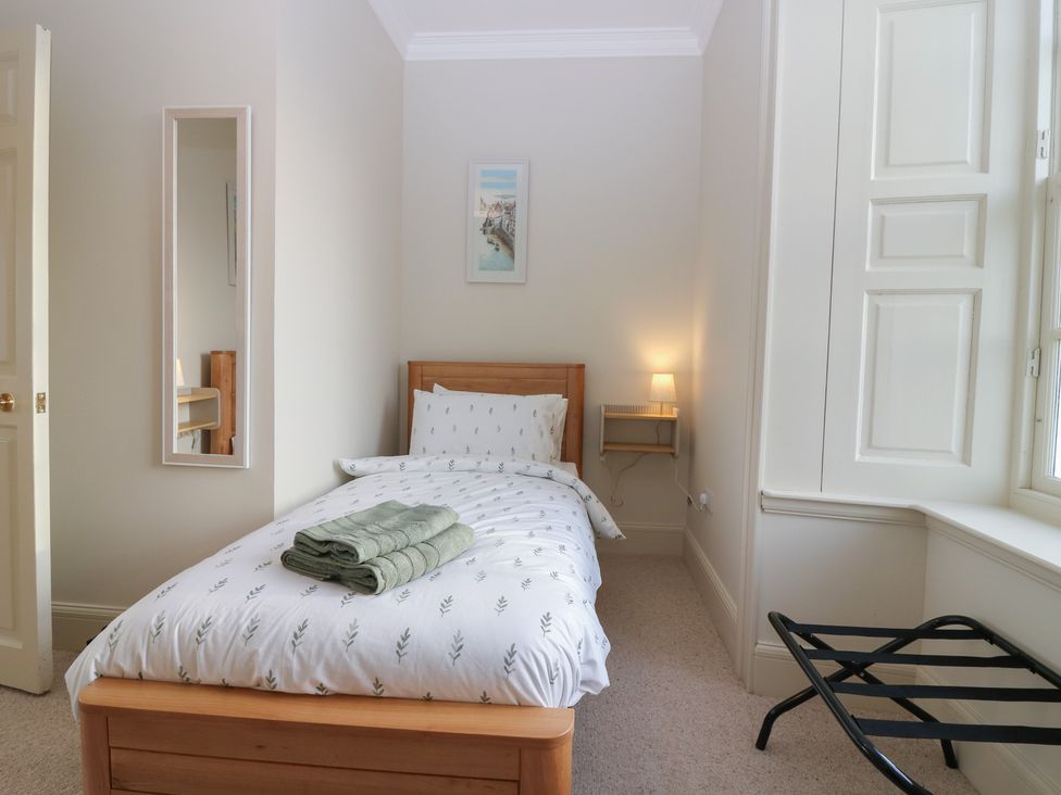 A bedroom with a bed and a lamp at Balmashanner Farmhouse in Forfar