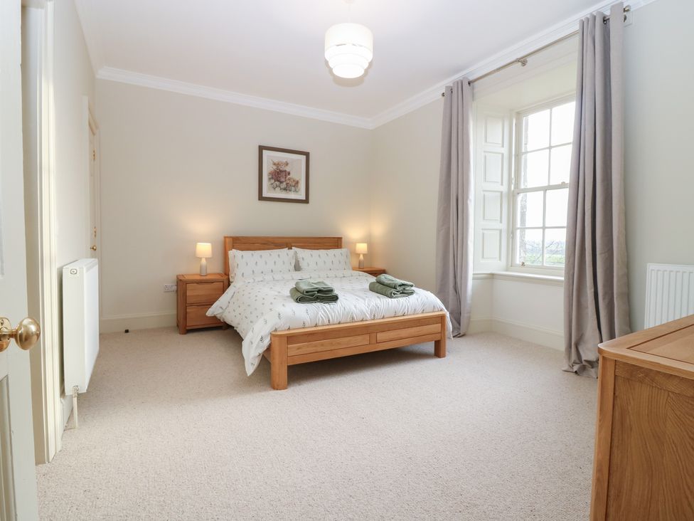 A bedroom with a bed and a window at Balmashanner Farmhouse in Forfar