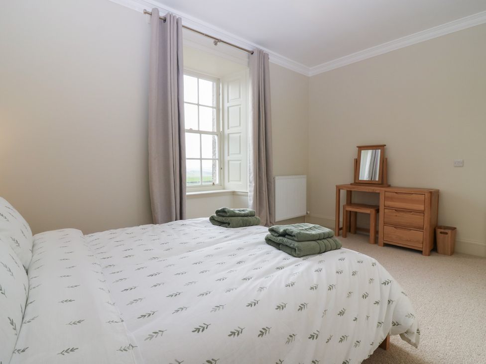 A bedroom with a bed and dressing table at Balmashanner Farmhouse in Forfar