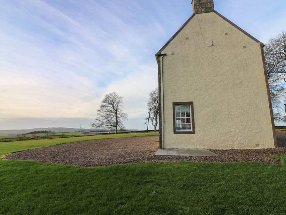 An exterior view of a house with a window and door at Balmashanner Farmhouse in Forfar