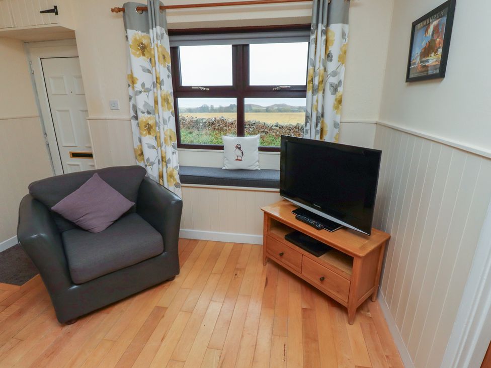 A living room with a chair and a television at Sunny Brae in Alnwick