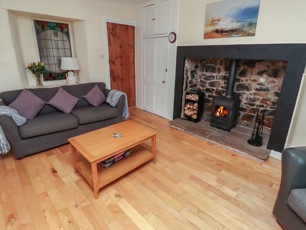 A living room with a fireplace and sofa at Sunny Brae in Alnwick