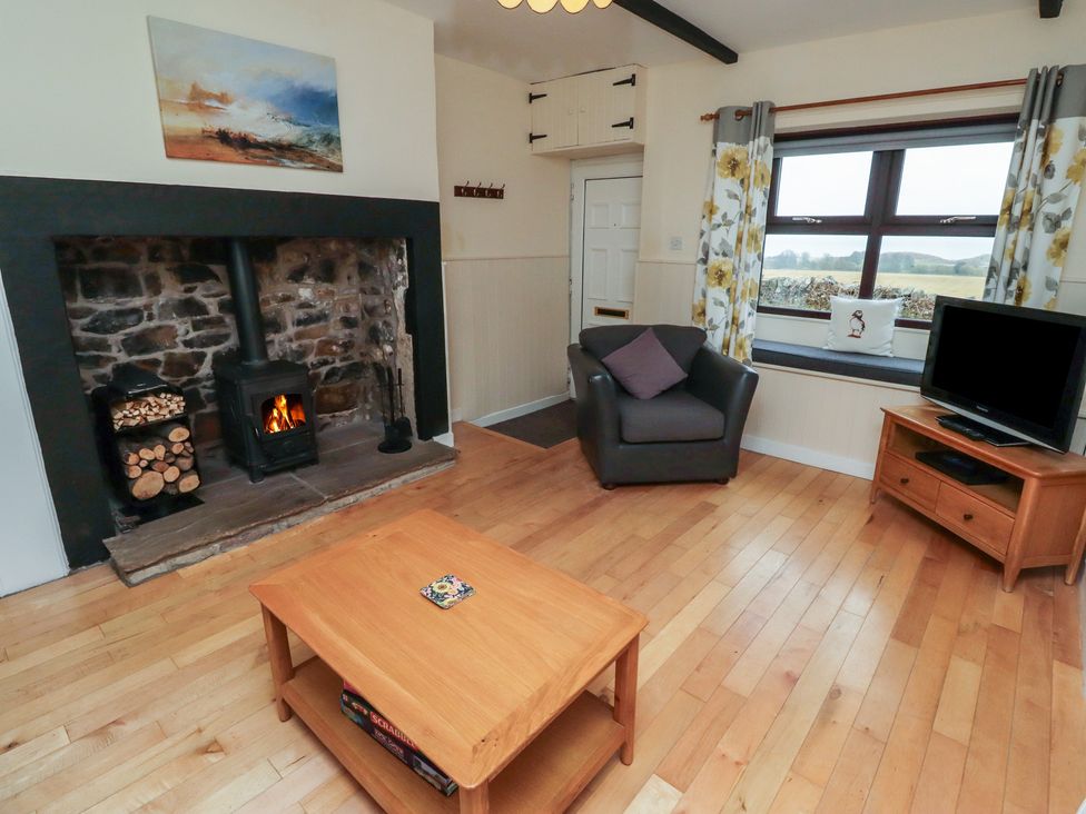 A living room with a fireplace and television at Sunny Brae in Alnwick