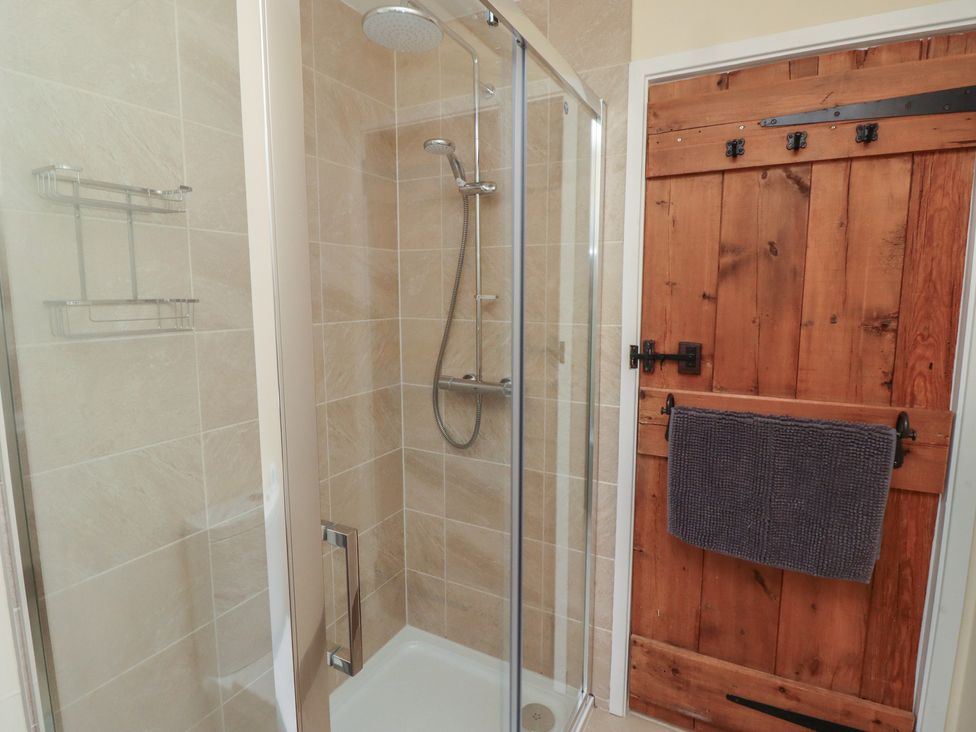 A shower with a wooden door at Sunny Brae in Alnwick