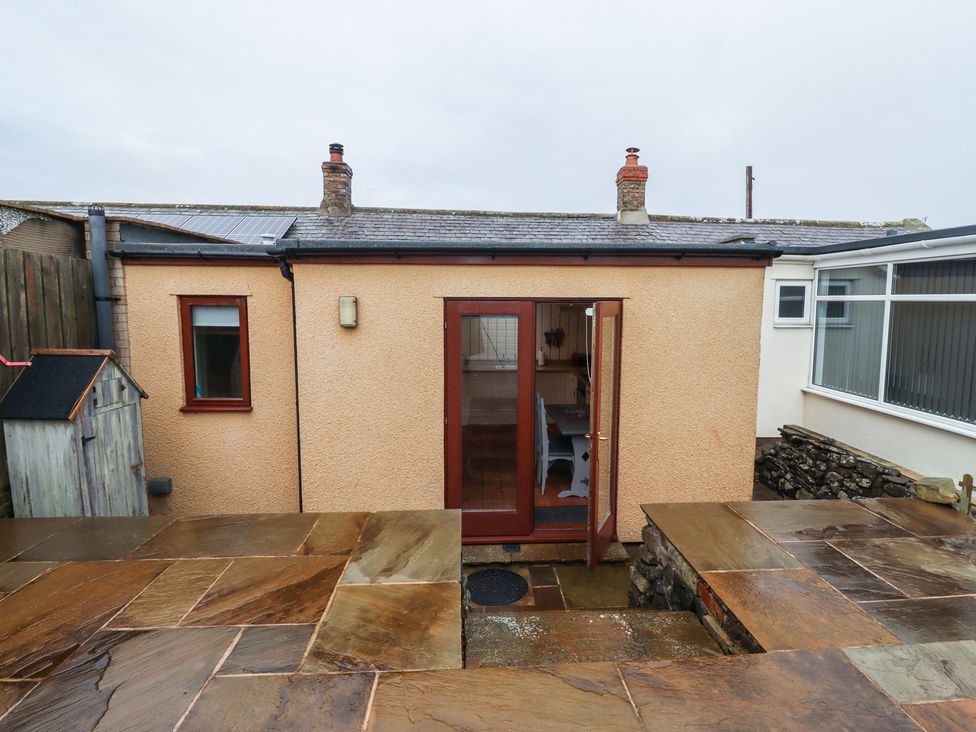 An exterior view of a small building with a door and patio stones at Sunny Brae in Alnwick