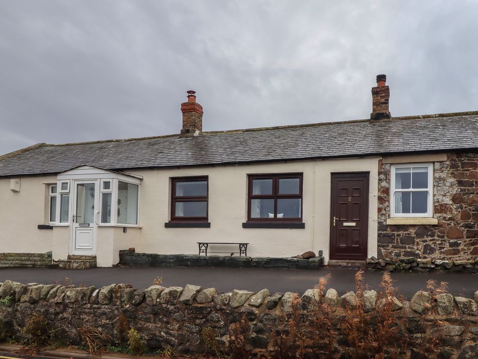 A cottage with a pathway and windows at Sunny Brae in Alnwick