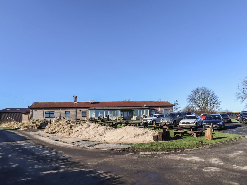 An outdoor area with a building and parked cars at 2 Sunny Brae Embleton