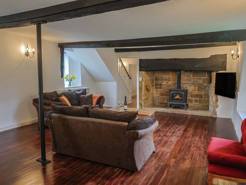 A living room with a fireplace and sofas at Manor Cottage in Kingstone near Ilminster