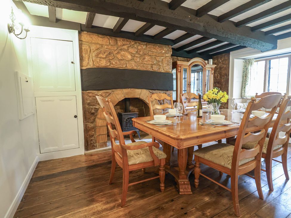 A dining room with a wooden table and chairs at Manor Cottage in Kingstone near Ilminster