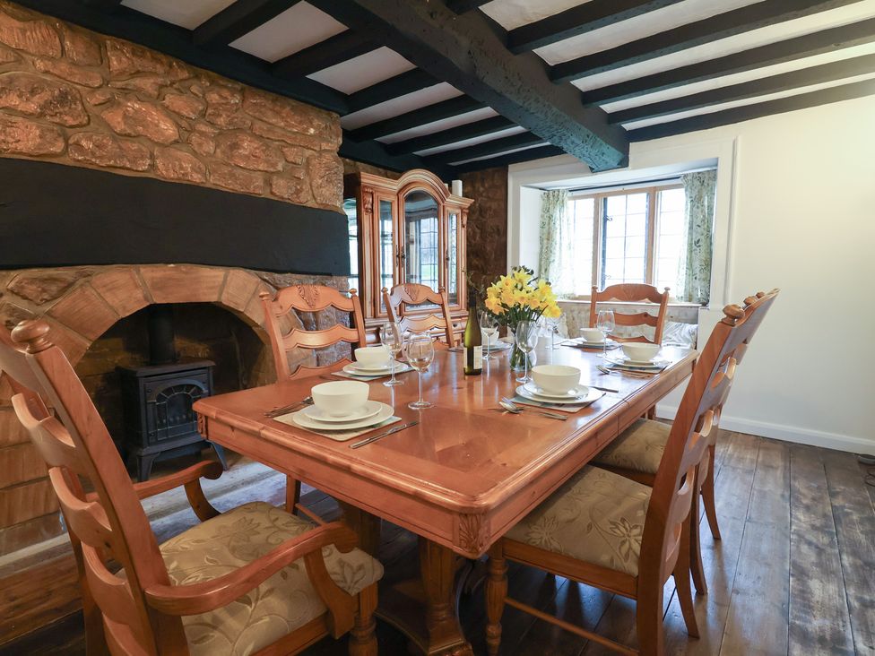 A dining room with a wooden table and chairs at Manor Cottage in Kingstone near Ilminster