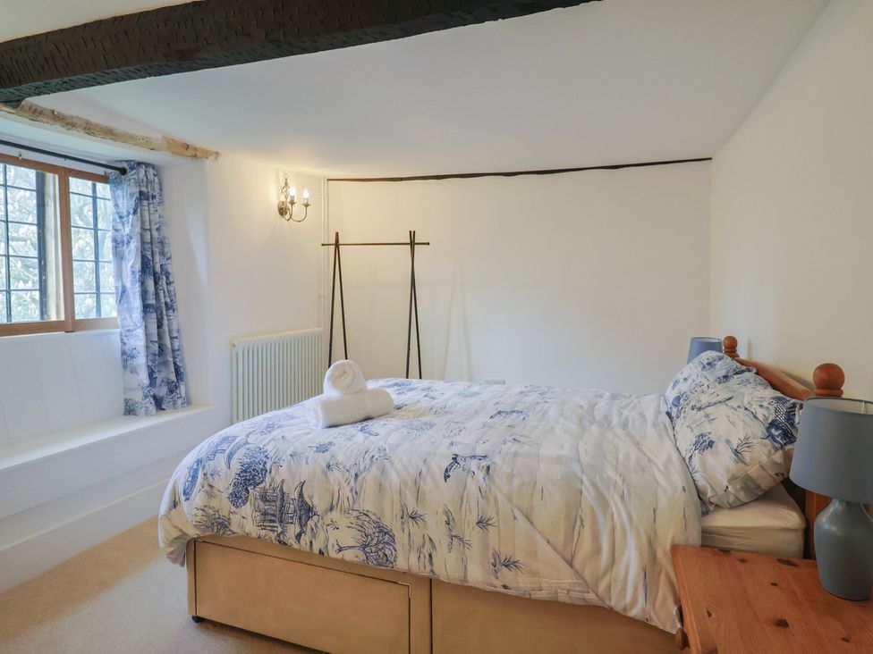 A bedroom with a bed and bedside table at Manor Cottage Kingstone near Ilminster