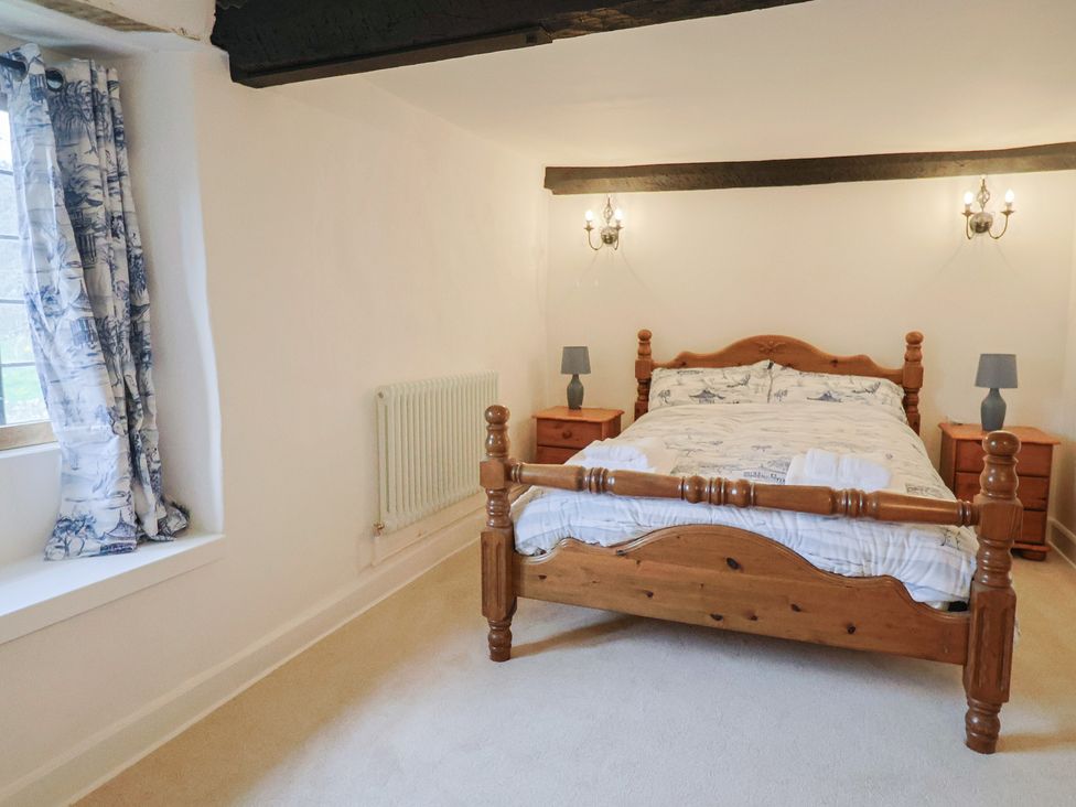 A bedroom with a wooden bed and nightstands at Manor Cottage near Ilminster