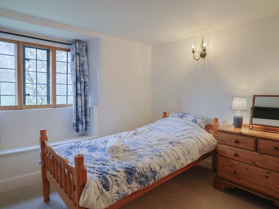 A bedroom with a bed and dresser at Manor Cottage in Kingstone near Ilminster
