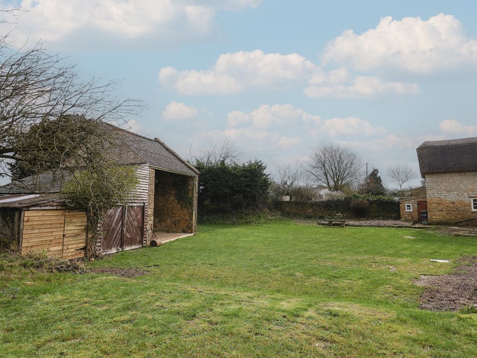 An outdoor area with a barn, grass, and trees at Manor Cottage Kingstone near Ilminster