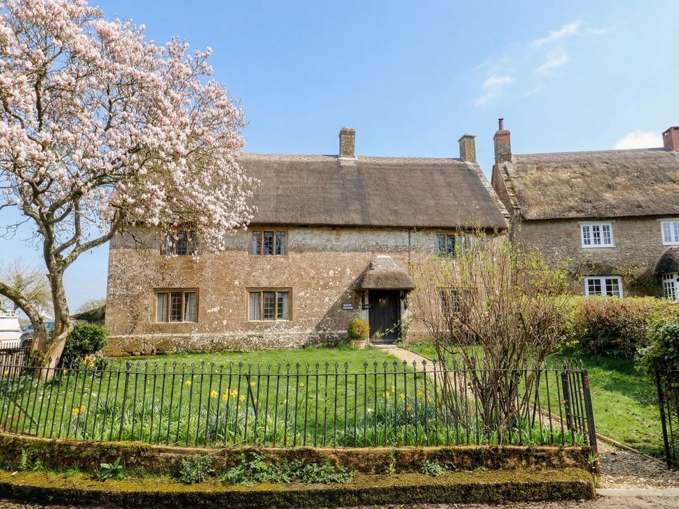 A cottage with a thatched roof and garden at Manor Cottage in Kingstone near Ilminster
