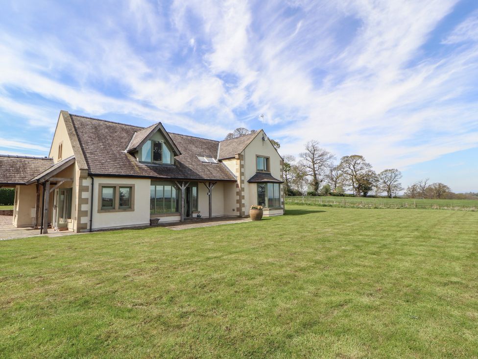 An exterior view of a house with grass and trees at Thimble Hill near Armathwaite