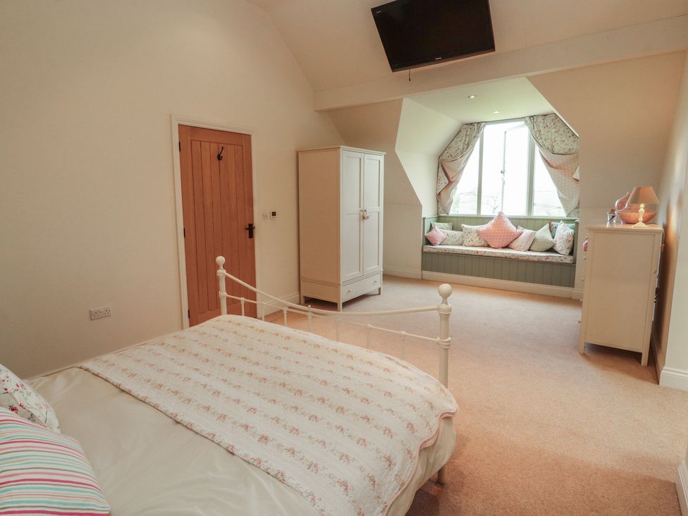 A bedroom with a bed and a wardrobe at Thimble Hill Near Armathwaite