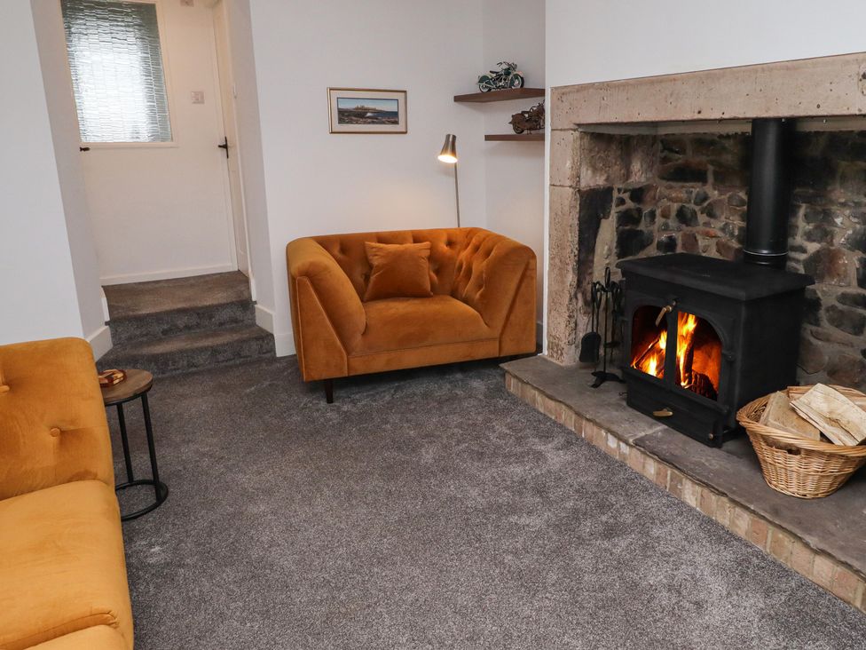 A living room with a fireplace and a sofa at 1 Sunnybrae in Alnwick