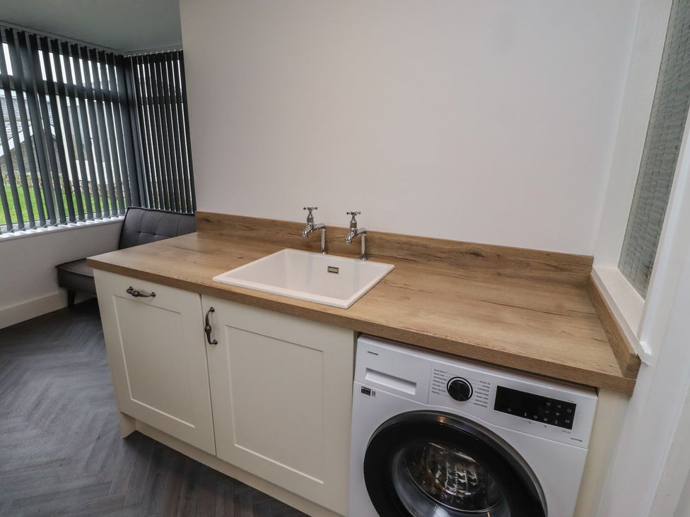 A laundry room with a sink and washing machine at 1 Sunnybrae Alnwick