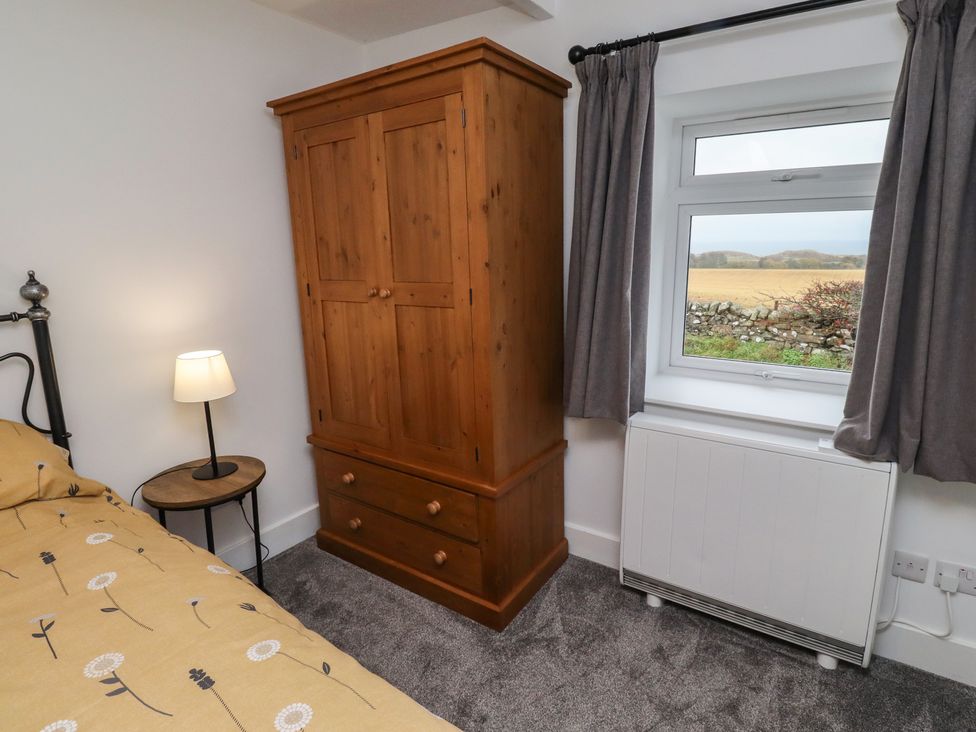 A bedroom with a bed, wardrobe, lamp and radiator at 1 Sunnybrae Alnwick