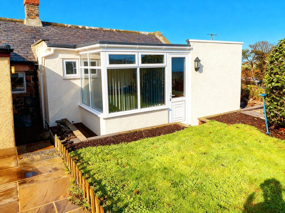 A garden area with a building and windows at 1 Sunny Brae Embleton
