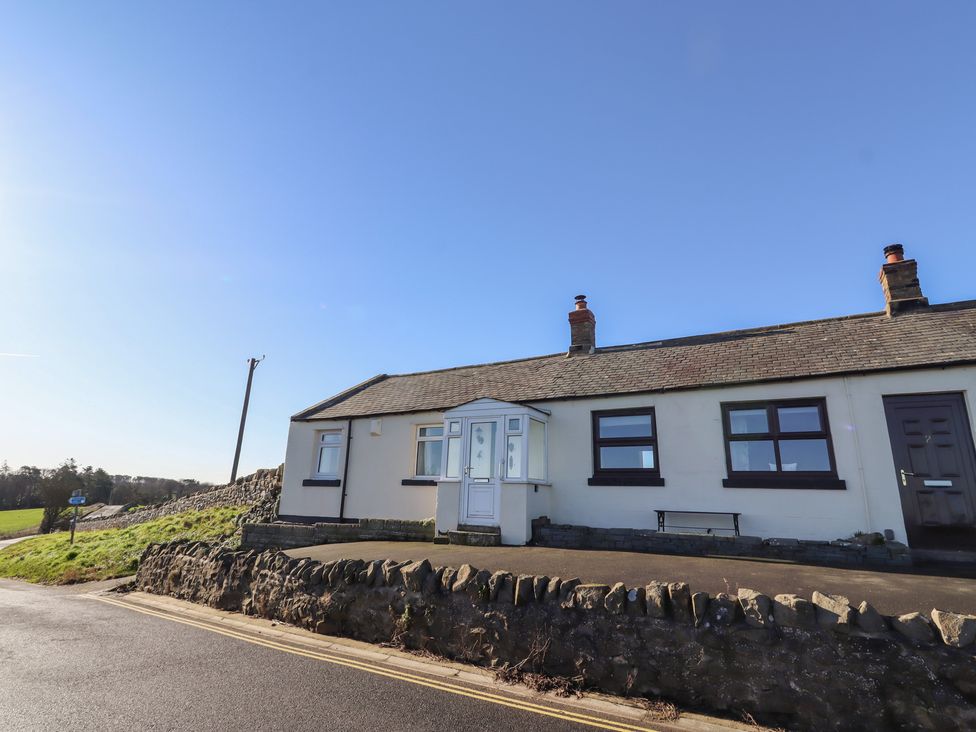 A house with a front door and windows at Harry's Cottage in Embleton