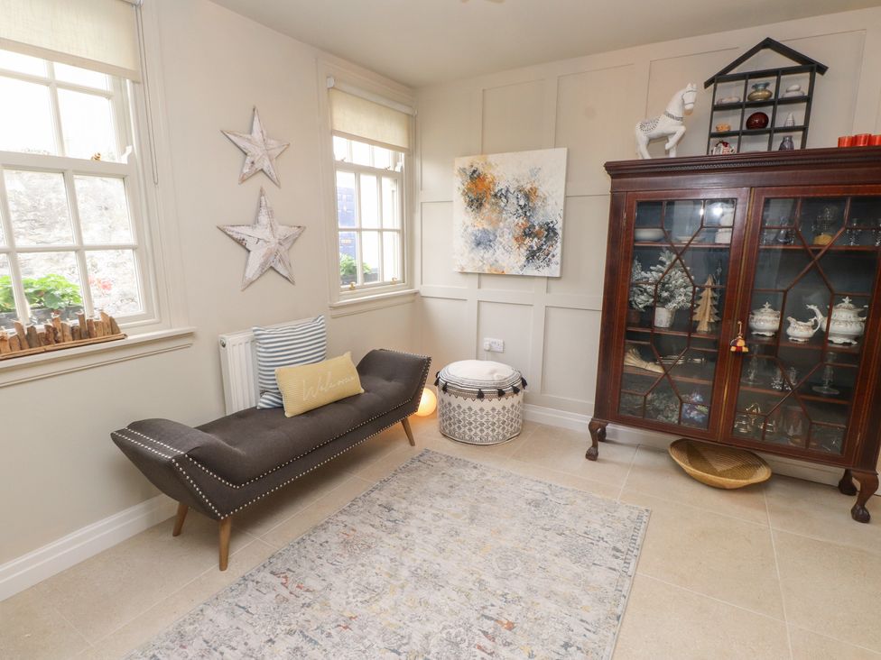 A snug with a sofa and cabinet at The Music Box in Beaumaris