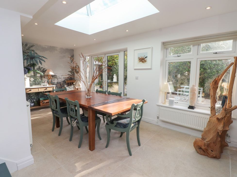 A dining room with a large table and chairs at The Music Box in Beaumaris