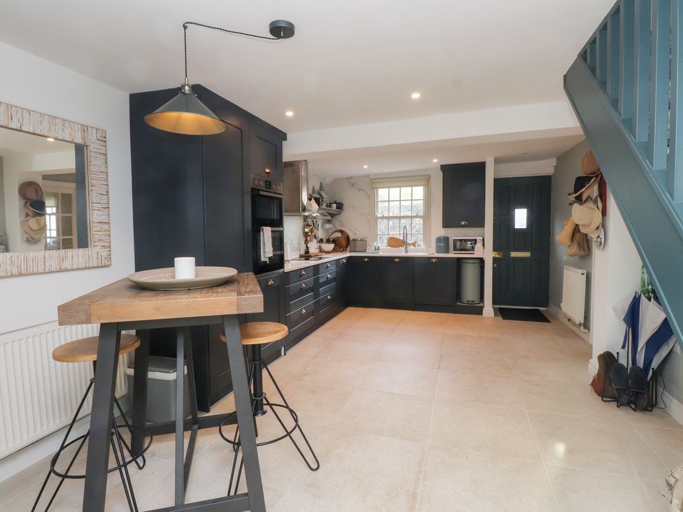 A kitchen with dark cabinets and a wooden counter at The Music Box in Beaumaris