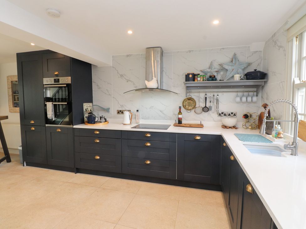 A kitchen with cabinets and a sink at The Music Box in Beaumaris